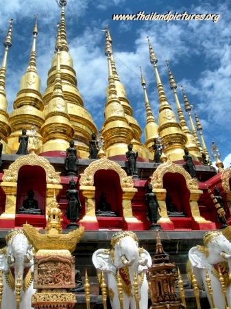 The golden thai temple with many towers and white elefants.